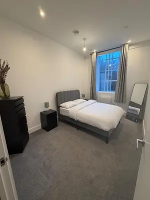 a bedroom with a bed and a window at Luxury Modern Apartment in Central Chelmsford in Chelmsford