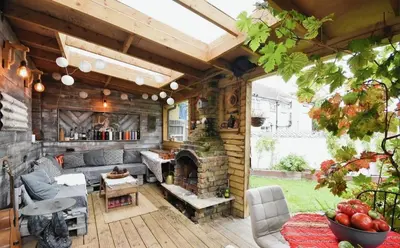 an outdoor living room with a stone fireplace at House in Harold Wood in Harold Wood