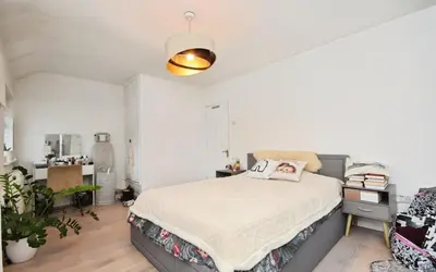 a bedroom with a bed and a desk at House in Harold Wood in Harold Wood