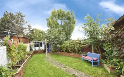 a garden with a blue bench in a yard at House in Harold Wood in Harold Wood