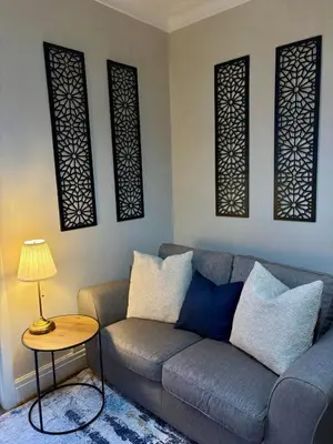 a living room with a couch and three windows at The Opulent Property Project Southend 4 Bed Sleeps 7 in Southend-on-Sea
