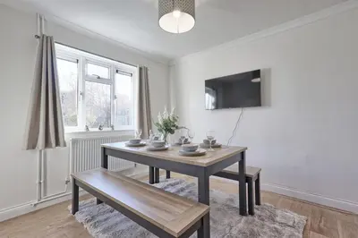 a dining room with a table and a bench at The Opulent Property Project Colchester 3BR nr Station Sleeps 6 Fastwifi Free Parking in Lexden