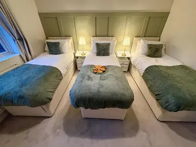a bedroom with three beds with a bowl on the middle at The Opulent Property Project Colchester 3BR nr Station Sleeps 6 Fastwifi Free Parking in Lexden