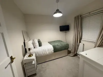 a small bedroom with a bed and a lamp at The Opulent Property Project Colchester 3BR nr Station Sleeps 6 Fastwifi Free Parking in Lexden