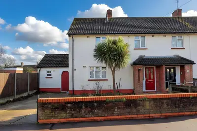 a white house with a palm tree in front of it at The Opulent Property Project Colchester 3BR nr Station Sleeps 6 Fastwifi Free Parking in Lexden