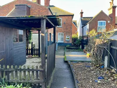 a yard with a fence and a house at Spacious 3 bedroom house in Central Leiston in Leiston