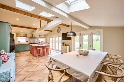 a kitchen and living room with a table and chairs at Host & Stay The Coral Cottage in Wymondham