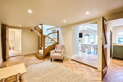 a living room with a table and a chair and a mirror at Host & Stay The Coral Cottage in Wymondham