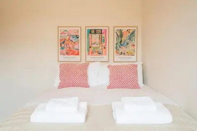 a bedroom with a bed with four pictures on the wall at Luxury Leiston 2 bed 2 bath with parking in Leiston