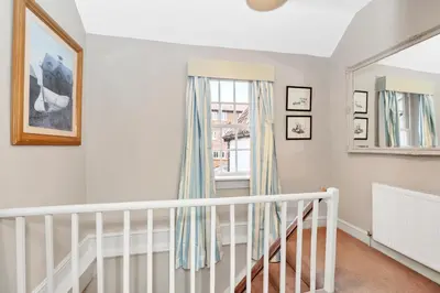 a white staircase in a home with a window at Charming Guildhall street - sleeps up to 6 guests in the Medieval Grid in Bury Saint Edmunds