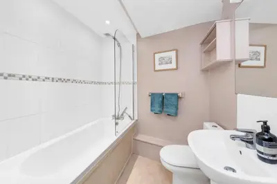 a white bathroom with a sink and a toilet at Charming Guildhall street - sleeps up to 6 guests in the Medieval Grid in Bury Saint Edmunds