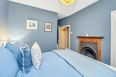 a blue bedroom with a bed and a fireplace at Charming Guildhall street - sleeps up to 6 guests in the Medieval Grid in Bury Saint Edmunds