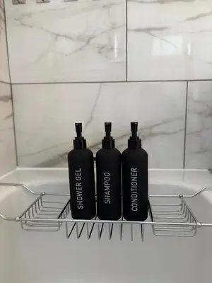 two black bottles sitting on a shelf in a bathroom at Cosy one bed Flat in Stevenage in Stevenage