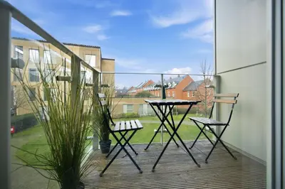 a balcony with a table and two chairs at Steps from Train Station - Modern 2-Bedroom with Balcony & Cambridge Amenities, Family Friendly in Cambridge
