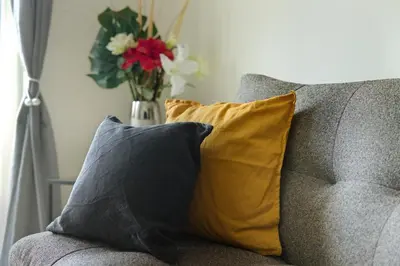 a vase of flowers sitting on top of a couch at Steps from Train Station - Modern 2-Bedroom with Balcony & Cambridge Amenities, Family Friendly in Cambridge