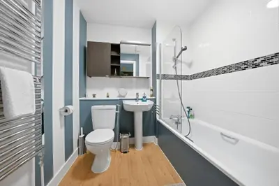a bathroom with a toilet and a sink and a shower at Steps from Train Station - Modern 2-Bedroom with Balcony & Cambridge Amenities, Family Friendly in Cambridge