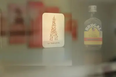 a bottle of alcohol next to a sign with an electricity tower at Steps from Train Station - Modern 2-Bedroom with Balcony & Cambridge Amenities, Family Friendly in Cambridge