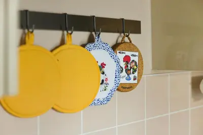 a group of pots and pans hanging on a rack in a kitchen at Steps from Train Station - Modern 2-Bedroom with Balcony & Cambridge Amenities, Family Friendly in Cambridge