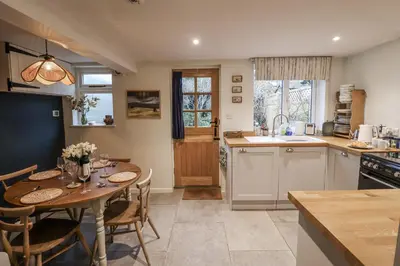 a kitchen and dining room with a table and chairs at The Old Post Box in Holton