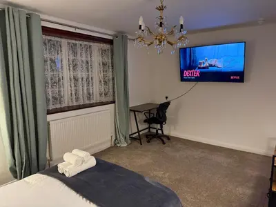 a bedroom with a bed and a flat screen tv at Stevenage Contractor & Family Retreat in Stevenage