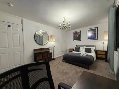 a bedroom with a bed and a mirror and a table at Stevenage Contractor & Family Retreat in Stevenage