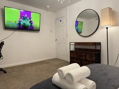 a room with a mirror and a tv on a wall at Stevenage Contractor & Family Retreat in Stevenage