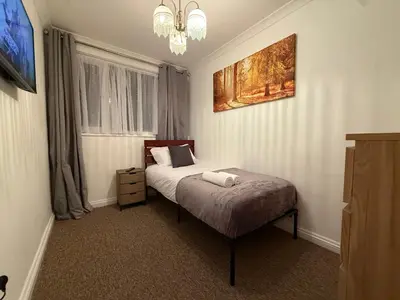a bedroom with a bed and a painting on the wall at Stevenage Contractor & Family Retreat in Stevenage