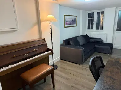 a living room with a piano and a couch at Stevenage Contractor & Family Retreat in Stevenage
