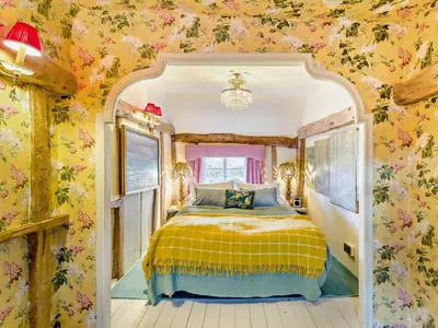 a bedroom with a bed with floral wallpaper at 4 Bed in Eye- oc-34389 in Thornham Magna