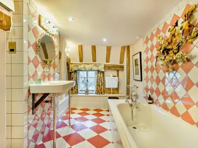 a bathroom with a tub and a sink at 4 Bed in Eye- oc-34389 in Thornham Magna