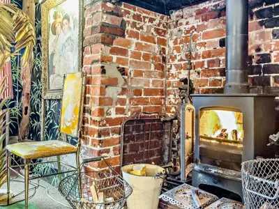 a brick fireplace with a chair and a brick wall at 4 Bed in Eye- oc-34389 in Thornham Magna
