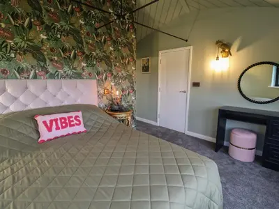 a bedroom with a large bed with a pink pillow on it at The Corn Silo in Ipswich