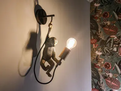a teddy bear hanging from a light on a wall at The Corn Silo in Ipswich