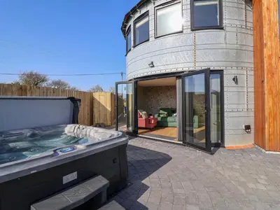 a building with a hot tub in a yard at The Corn Silo in Ipswich