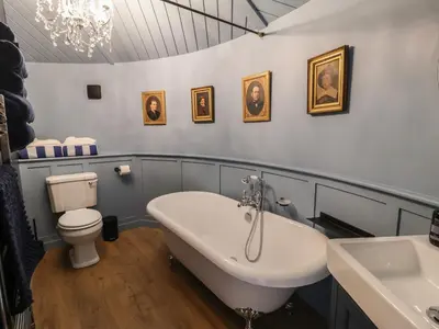 a bathroom with a tub and a toilet and a sink at The Barley Silo in Ipswich