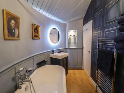 a bathroom with a white tub and a sink at The Barley Silo in Ipswich