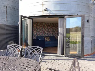a patio with a couch and a table and chairs at The Barley Silo in Ipswich
