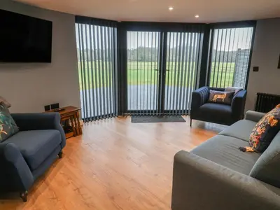 a living room with two couches and a flat screen tv at The Barley Silo in Ipswich