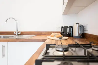 a kitchen counter with a stove and a sink at Ploughman’s Green, Blythburgh in Halesworth