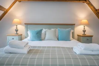 a bedroom with a bed with two pillows on it at Ploughman’s Green, Blythburgh in Halesworth