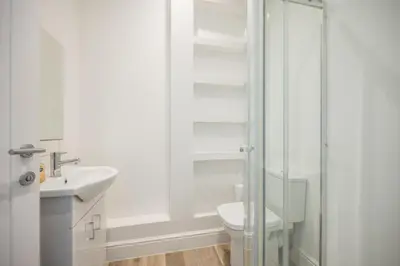 a bathroom with a toilet and a glass shower at Ploughman’s Green, Blythburgh in Halesworth