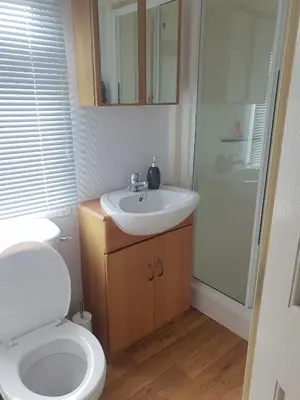 a bathroom with a white toilet and a sink at Hutleys Caravan Holiday Home - St Osyth - Clacton-on-Sea in Saint Osyth