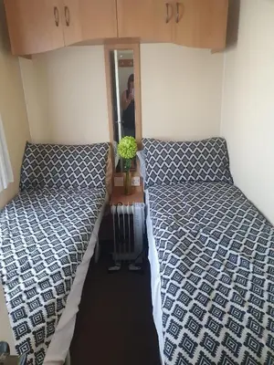 a small room with two beds and a mirror at Hutleys Caravan Holiday Home - St Osyth - Clacton-on-Sea in Saint Osyth