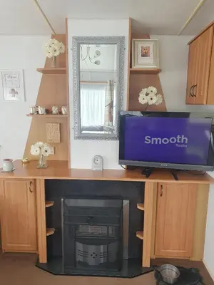 a desk with a tv and a fireplace in a room at Hutleys Caravan Holiday Home - St Osyth - Clacton-on-Sea in Saint Osyth