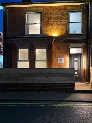 a brick building with a fence in front of it at Sleep Hub in Leiston