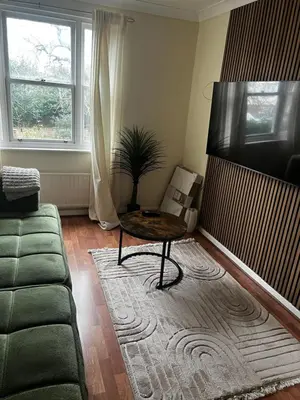 a living room with a couch and a table at Single Room in town house in Rochford