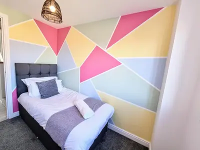 a bedroom with a colorful accent wall at Basildon Premium Crew Stay 4 BR, Sleeps 8, Parking in Laindon