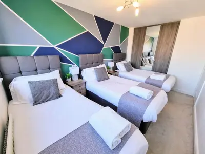 a room with three beds and a colorful wall at Basildon Premium Crew Stay 4 BR, Sleeps 8, Parking in Laindon