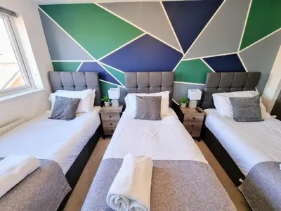 two beds in a room with a geometric wall at Basildon Premium Crew Stay 4 BR, Sleeps 8, Parking in Laindon