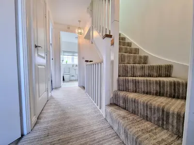 a hallway with a staircase with a carpeted floor at Basildon Premium Crew Stay 4 BR, Sleeps 8, Parking in Laindon